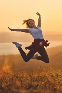 BioMetrix-NeuroMRI-Treatment A woman jumps for joy in the sunset. Get a BioMetrix NeuroMRI scan from Discovery Health Healing Center in Green Bay.