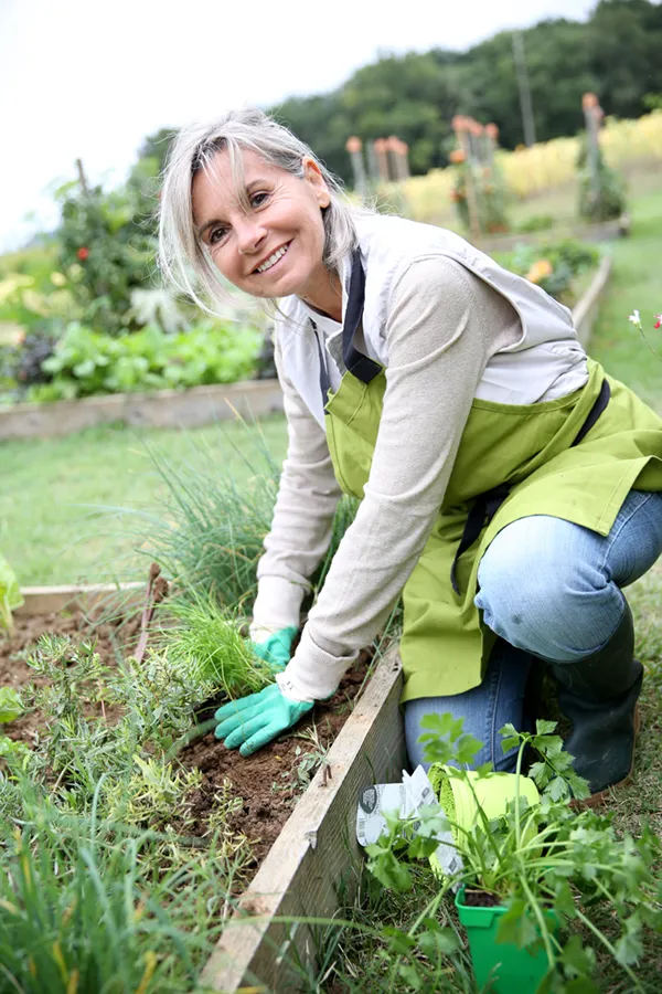 Cellular-Regeneration-Treatment A mature woman happily working in her garden. Get cellular regeneration treatment from Discovery Health Healing Center in Green Bay.