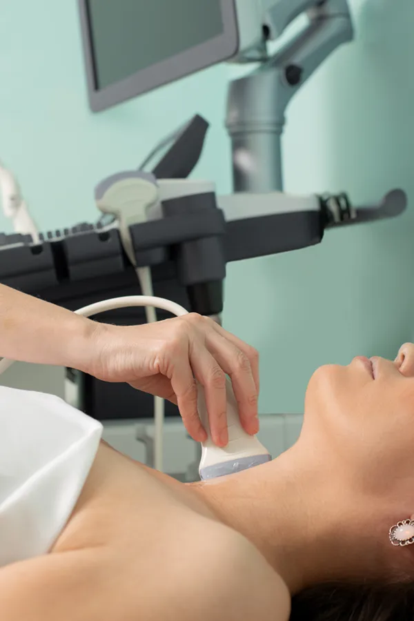 Hashimotos-Thyroiditis-Treatment A woman gets a thyroid scan from a doctor in a clinic. Get help with Hashimoto's Thyroiditis from Discovery Health Healing Center in Green Bay.