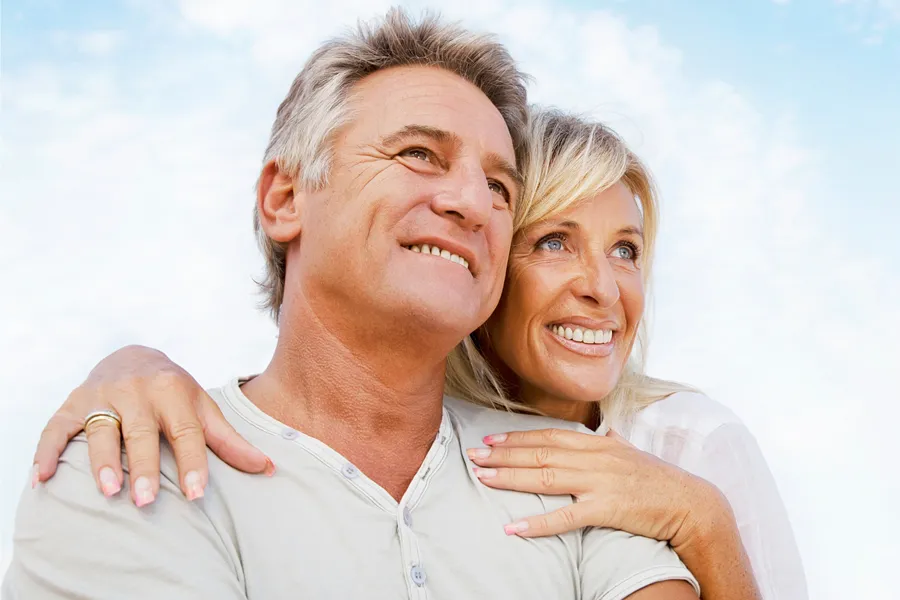 Holistic-Medicine-Clinic A happy middle-aged man and woman look up into a beatiful blue sky with white clouds. Schedule Holistic Medicine treatement from Discovery Health Healing Center in Green Bay.