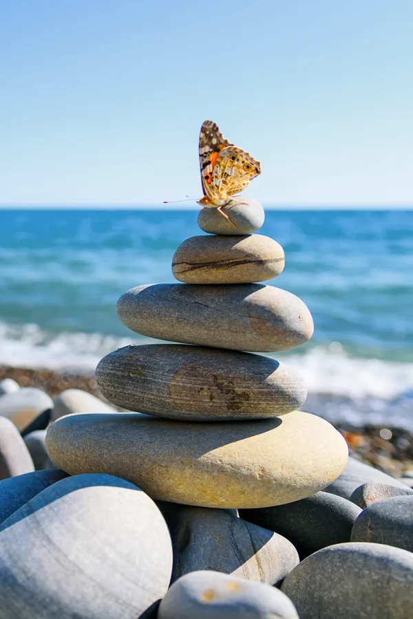 Holistic-Medicine-Treatment A stack of smooth rocks by the ocean. Schedule Holistic Medicine treatement from Discovery Health Healing Center in Green Bay.