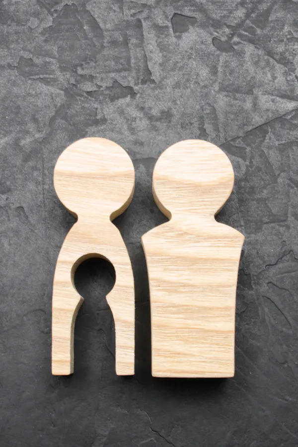 Infertility-Treatment Woodcut figures of a man and woman with a child-shaped area cut out from the woman figure. Get treatment for infertility from Discovery Health Healing Center in Green Bay.