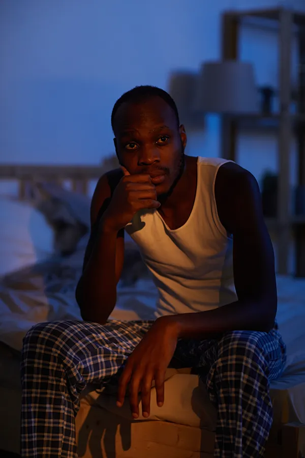 Insomnia-Treatment A man sits on the edge of his bed late at night, unable to sleep. Get treatment for Insomnia from Discovery Health Healing Center in Green Bay.