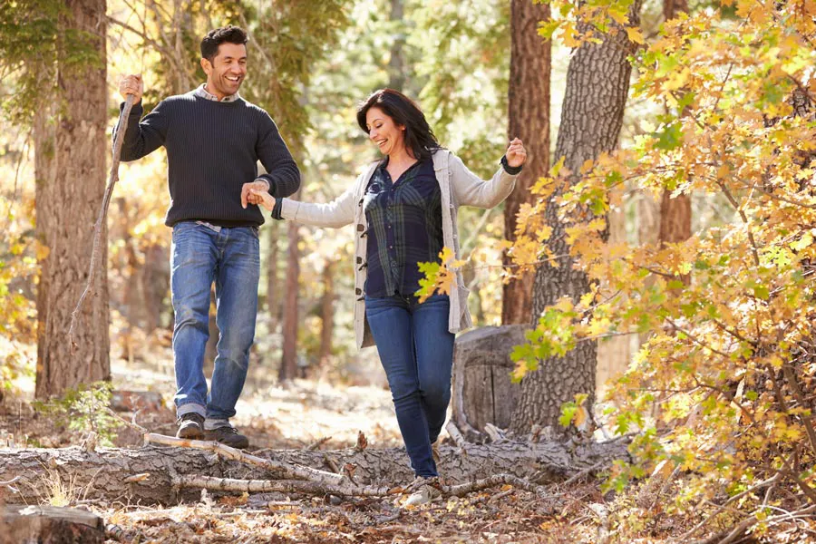 Lyme-Disease-Clinic A couple happily hiking in the forest in fall. Get treatment for Lyme Disease from Discovery Health Healing Center in Green Bay.