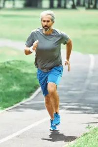 NovoTHOR®-Full-Body-Red-Light-Therapy-Treatment A middle-aged man running. Get NovoTHOR® Full Body Red Light Therapy from Discovery Health Healing Center in Green Bay.