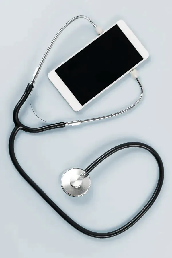 A smartphone with a stethoscope attached to it, symbolizing Telemedicine treatment from Discovery Health Healing Center in Green Bay.