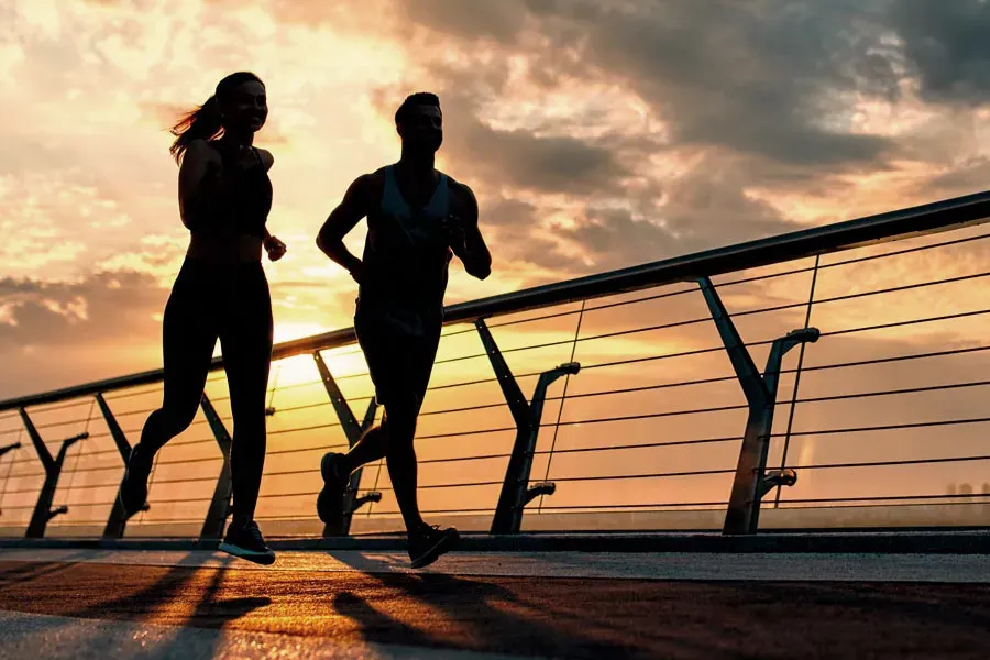 Weight-Loss-Clinic-2 A couple jogs on a bridge at sunrise. Get Weight Loss treatment from Discovery Health Healing Center in Green Bay.